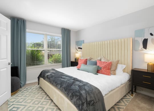 a bedroom with a bed and a large window
