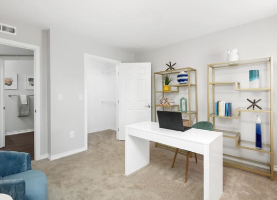 a living room with a white desk with a laptop on it