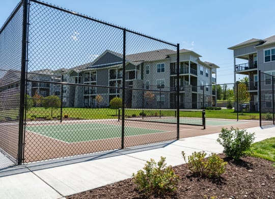 a tennis court at the whispering winds apartments in pearland, tx