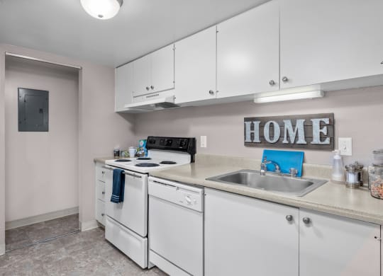 a kitchen with white appliances and white cabinets and a sink