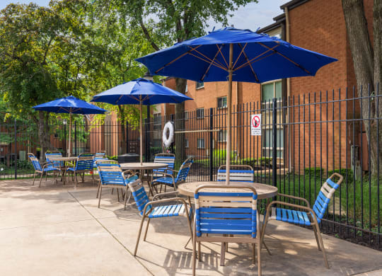 a patio with tables and chairs and umbrellas