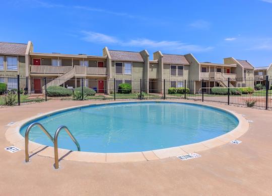 a swimming pool with an apartment building in the background