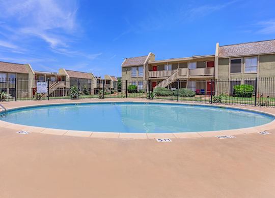 a swimming pool with an apartment building in the background