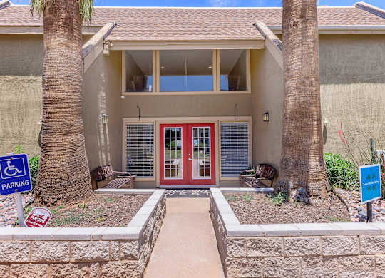 a house with a red door and two palm trees