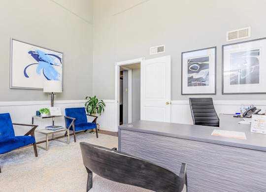 a room with a desk and chairs and a door