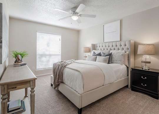 a bedroom with a bed and a ceiling fan