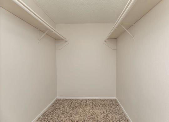 an empty room with white walls and two shelves on the wall