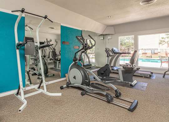 a gym with exercise equipment and a pool