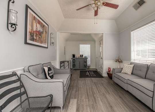 a living room with two couches and a ceiling fan