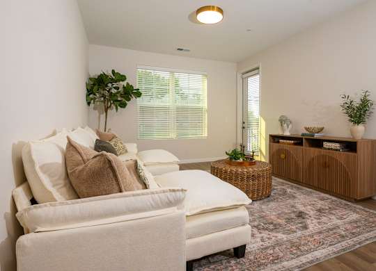 A living room with a white sofa and a wooden cabinet.