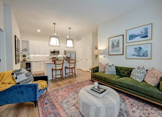 A living room with a green couch and a rug.