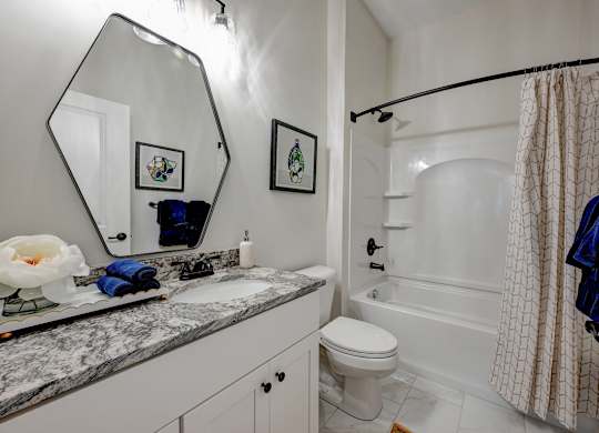 A bathroom with a marble countertop and a white toilet.