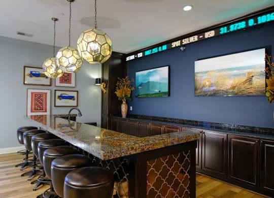 A bar with a row of stools and a counter with a patterned design.