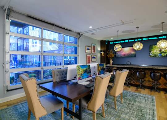 A dining room with a table and chairs and a view of a balcony.