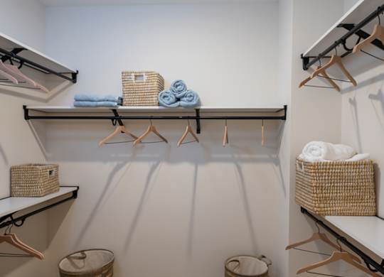 A laundry room with a white wall and a wooden floor.