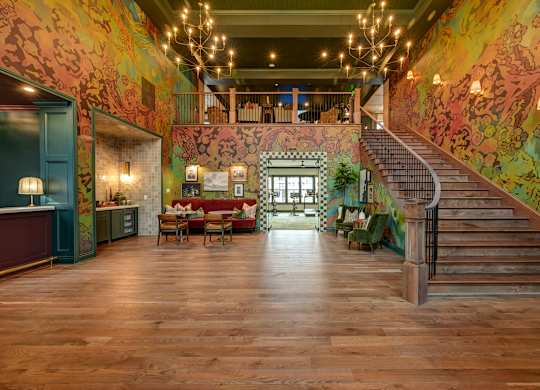 A brightly lit hallway with a staircase and a dining area.