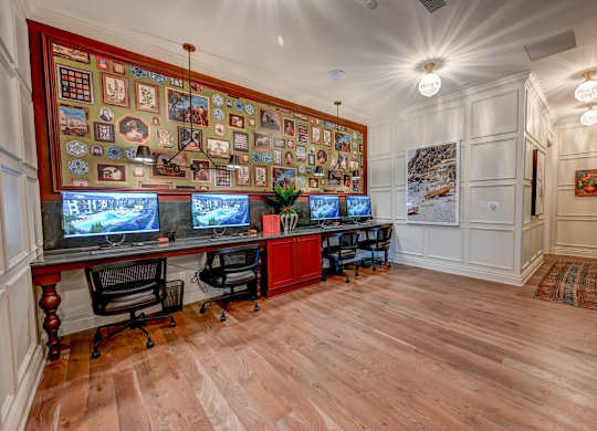 A room with a wooden floor and a wall covered in pictures and posters.