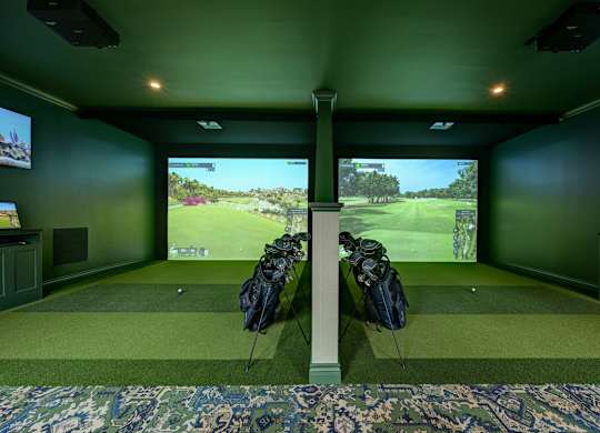 A room with green walls and a large screen showing a golf course.