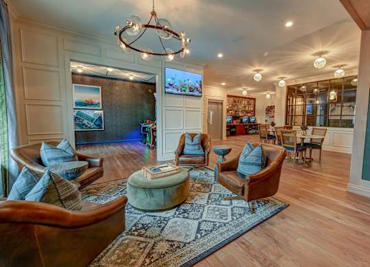 A living room with a large rug and a chandelier.