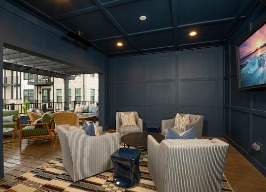 A living room with a large screen on the wall.