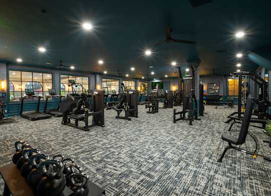 A gym with a variety of equipment including weights and machines.