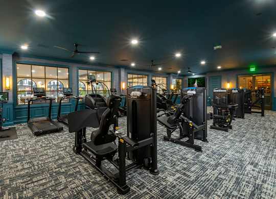 A gym with a variety of equipment including treadmills, stationary bikes, and weight machines.