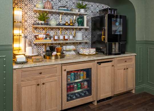 A kitchen with wooden cabinets and a green wall.