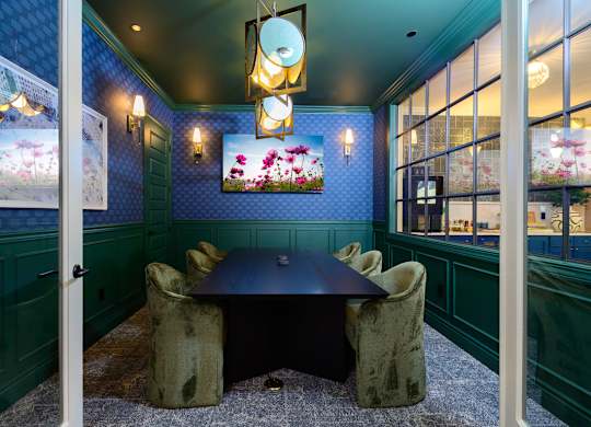 A dining room with a table and chairs.