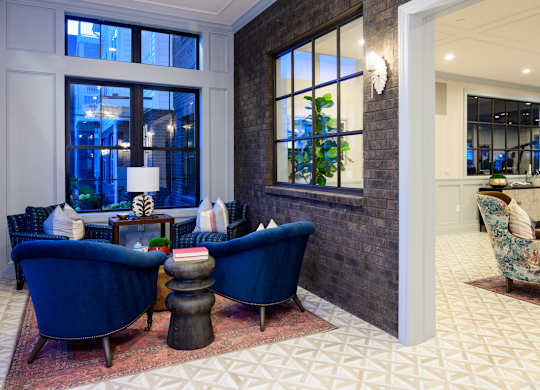 Sitting area with blue velvet chairs and large windows at Fairmont Apartments, Westerville, 43081