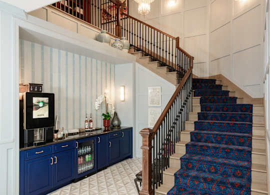 Grand staircase with beverage station and decorative carpet at Fairmont Apartments, Westerville, Ohio