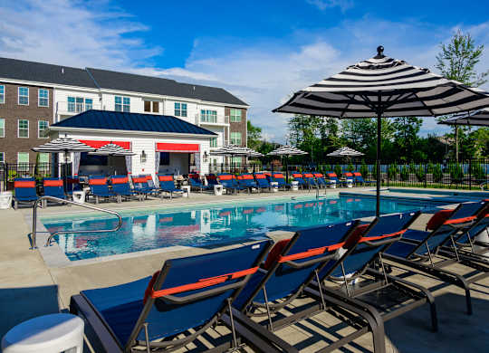 Resort style pool with lounge chairs and umbrellas at Fairmont Apartments, Westerville, 43081