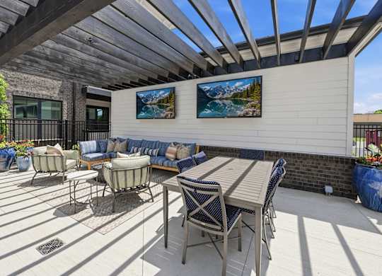 A patio with a table and chairs under a roof.