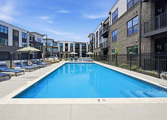 A swimming pool in front of apartment buildings.