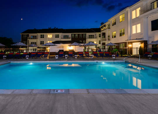 Evening pool deck with striped chairs and courtyard at Fairmont Apartments, Westerville, 43081