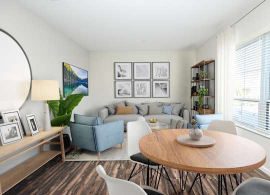 A living room with a grey couch, a wooden table, and a painting on the wall.