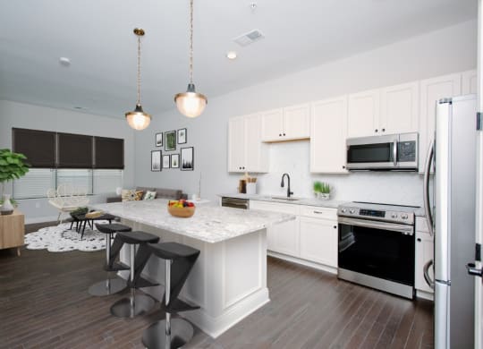 a kitchen with white cabinets and a white island with three stools at Fairfax, Grandview, OH, 43212
