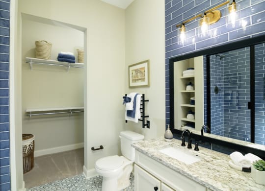 a bathroom with blue tile and a white toilet at Fairfax, Ohio