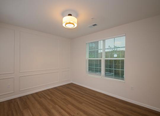 A room with a window and a light on the ceiling.