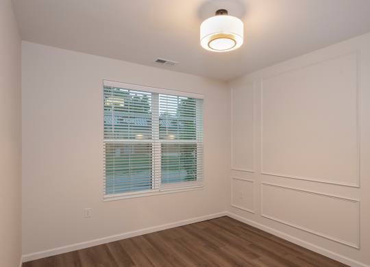 A room with a window and wooden floors.