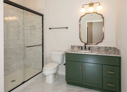 A bathroom with a green cabinet and a marble countertop.