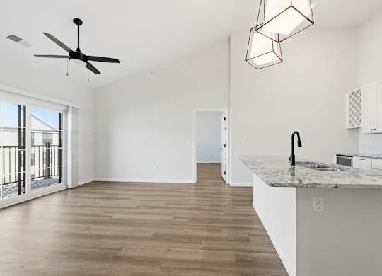 A kitchen with a marble countertop and a ceiling fan.