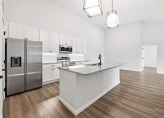 A kitchen with a stainless steel refrigerator, microwave, and oven.