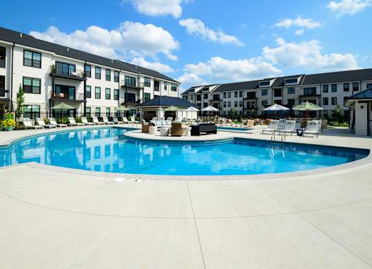 A large swimming pool in front of apartment buildings.