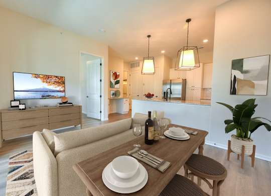 A modern dining room with a wooden table set for two.
