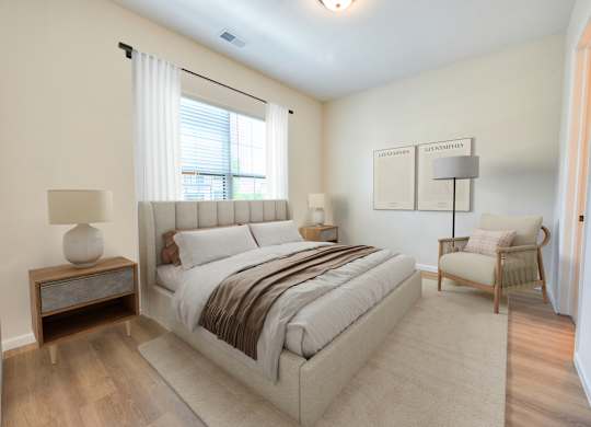 A bedroom with a large bed and a chair.