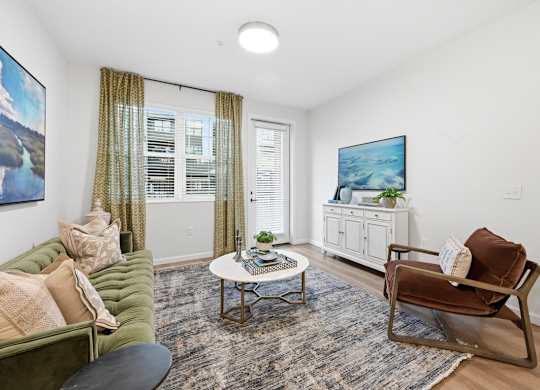 A living room with a green couch, a coffee table, and a painting on the wall.