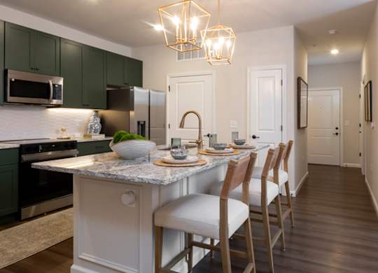A kitchen with a table and chairs.