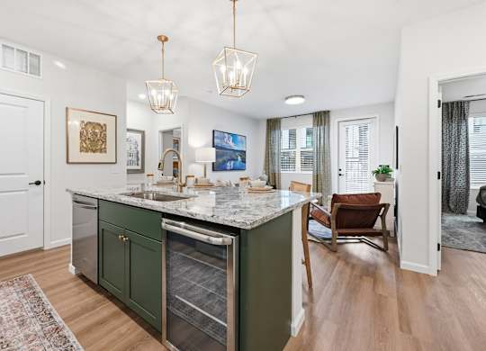 A kitchen with green cabinets and a marble countertop.