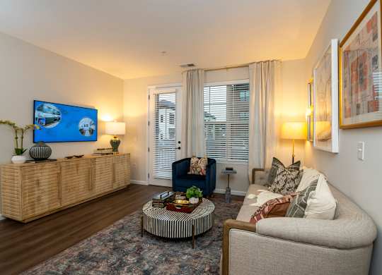 A living room with a sofa, a coffee table, and a painting on the wall.