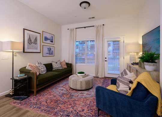 A living room with a blue couch and a rug.